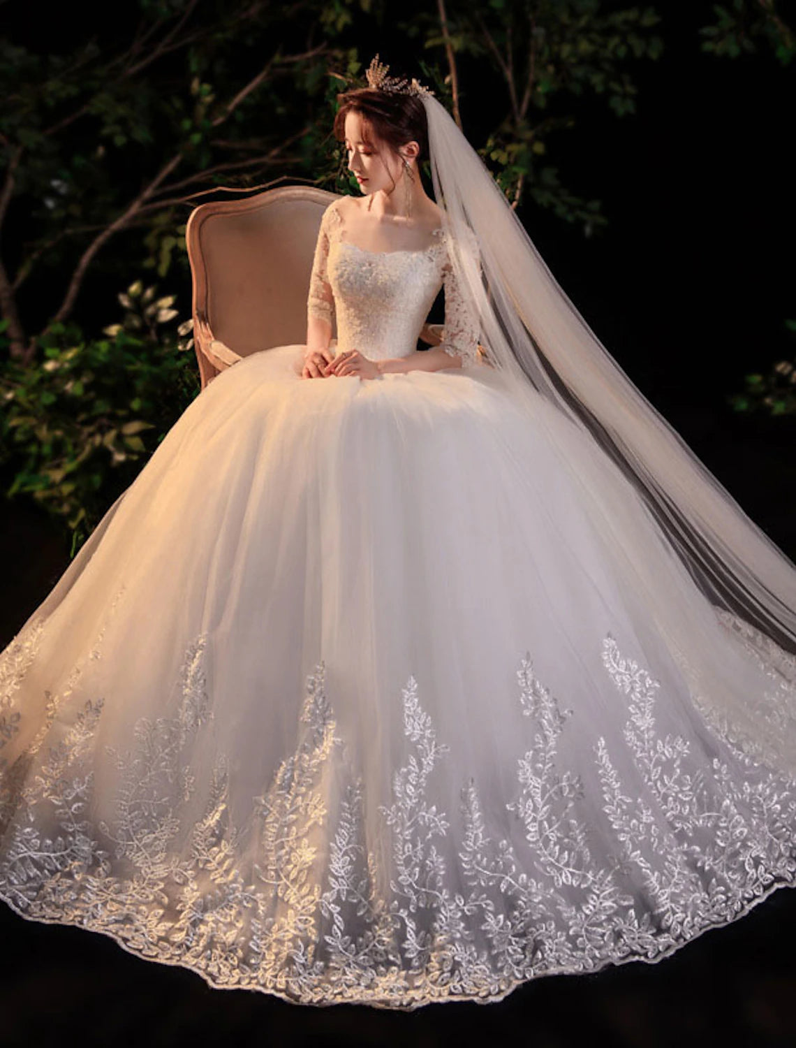 Full length view of a bride wearing a lace ball gown wedding dress with appliques.