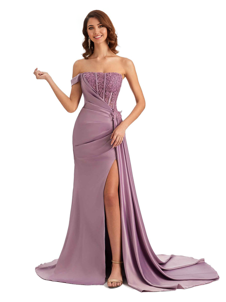 Woman wearing an elegant mermaid off-shoulder dress with applique and side slit.