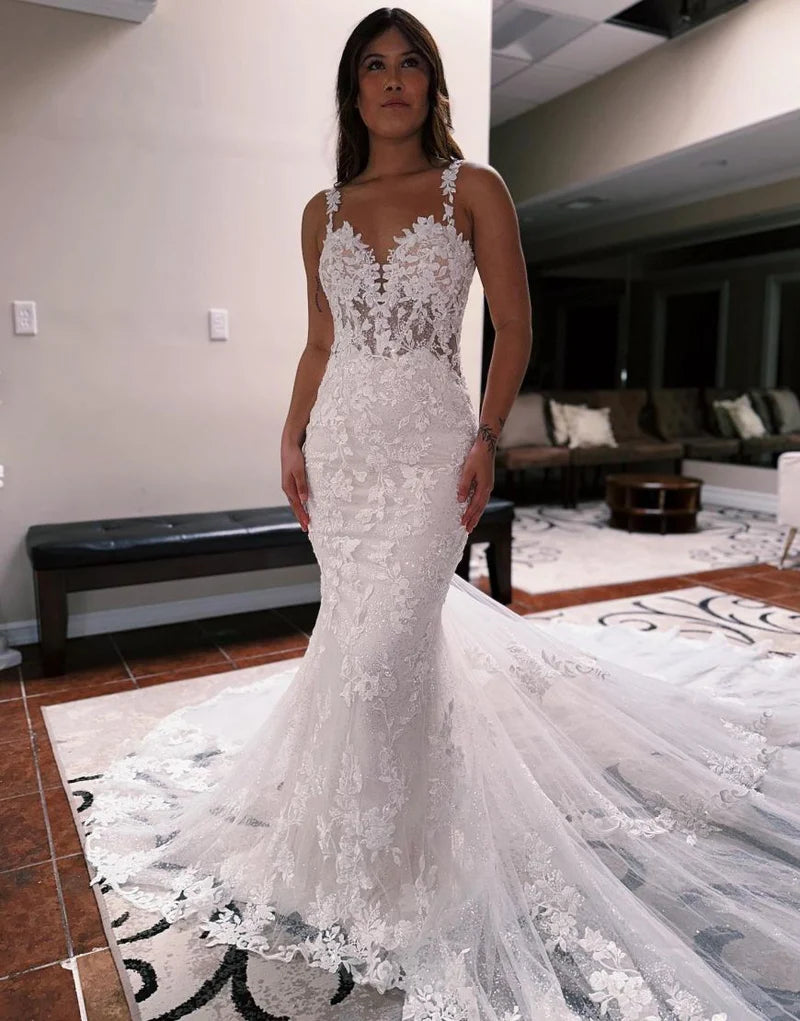Elegant mermaid wedding dress with spaghetti straps and open back.
