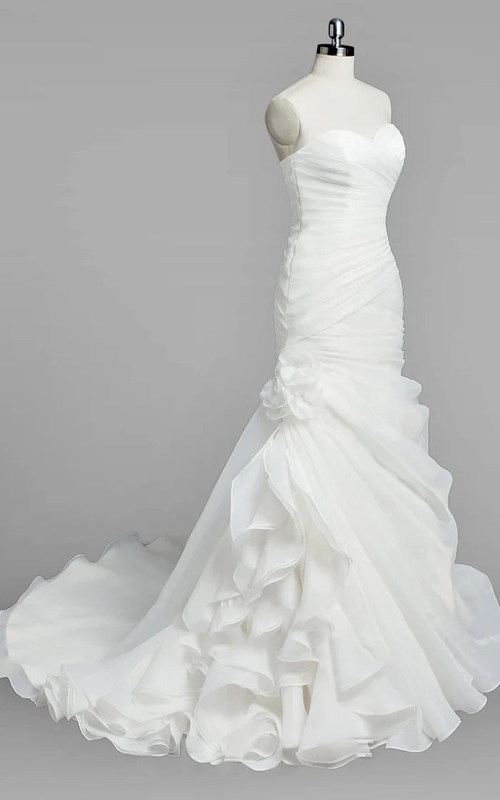 Close-up of the ruched detail and ruffles on a white mermaid wedding dress.