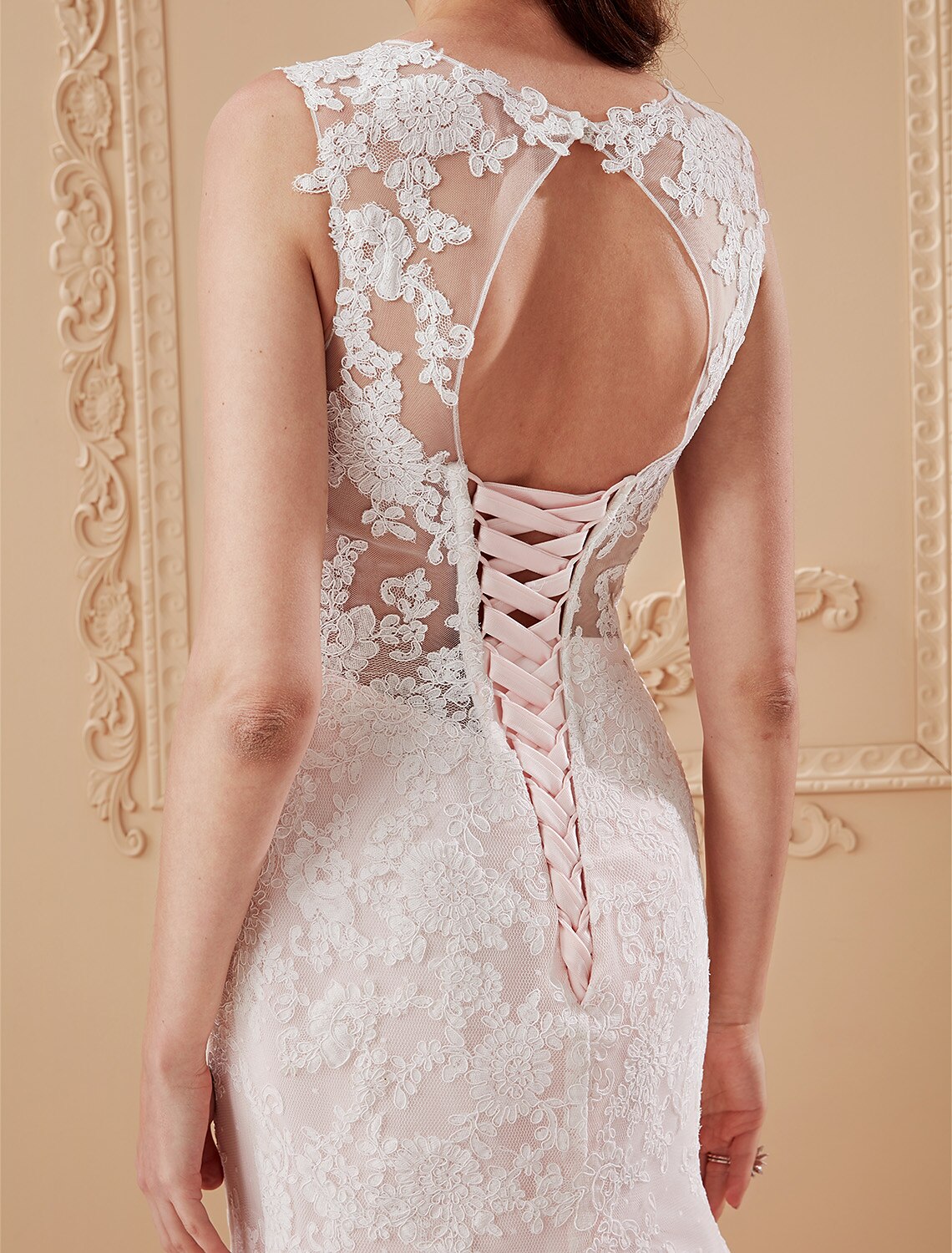Side view of a bride wearing a lace and tulle wedding gown.