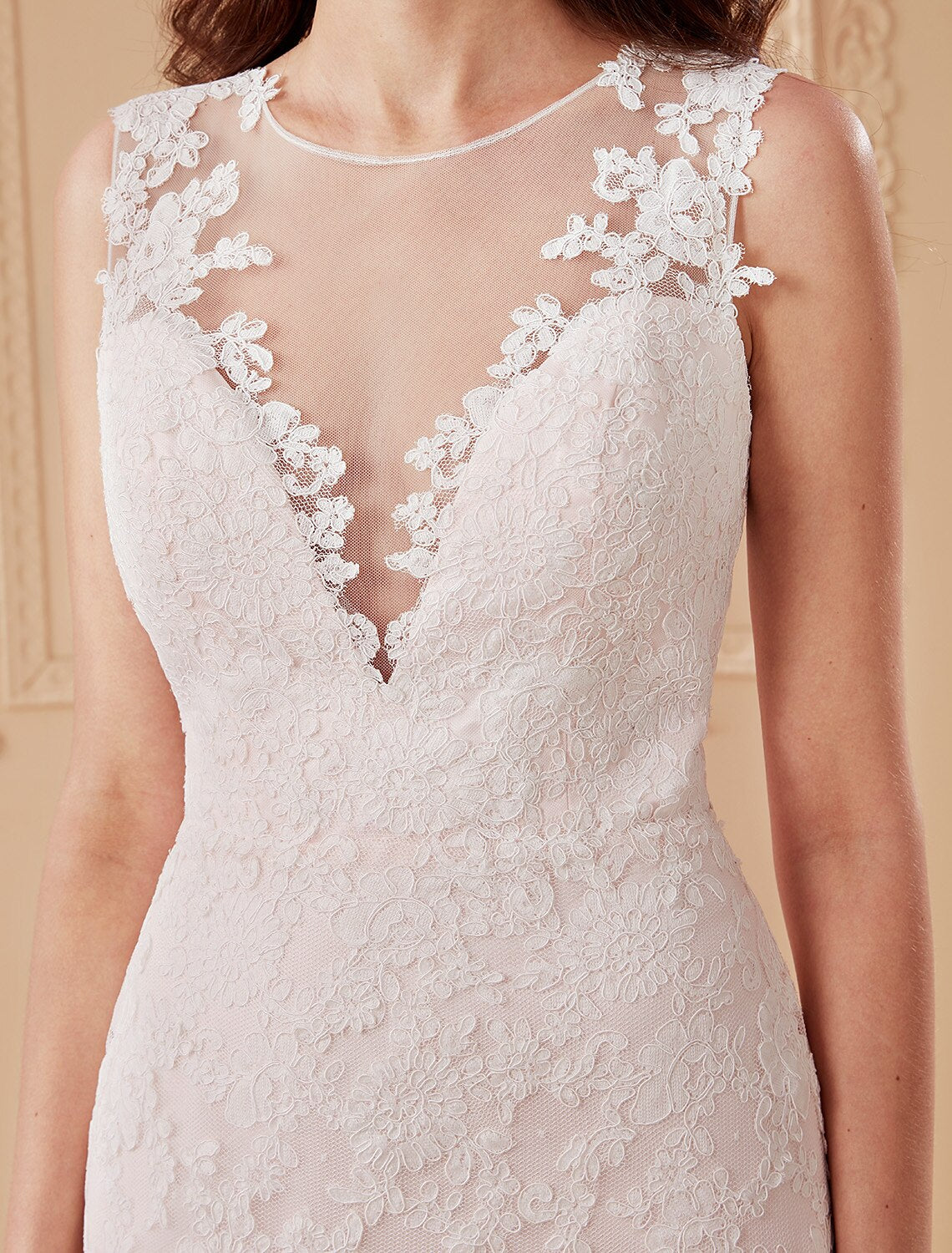 Close-up of lace appliques on a plunging neck wedding dress.