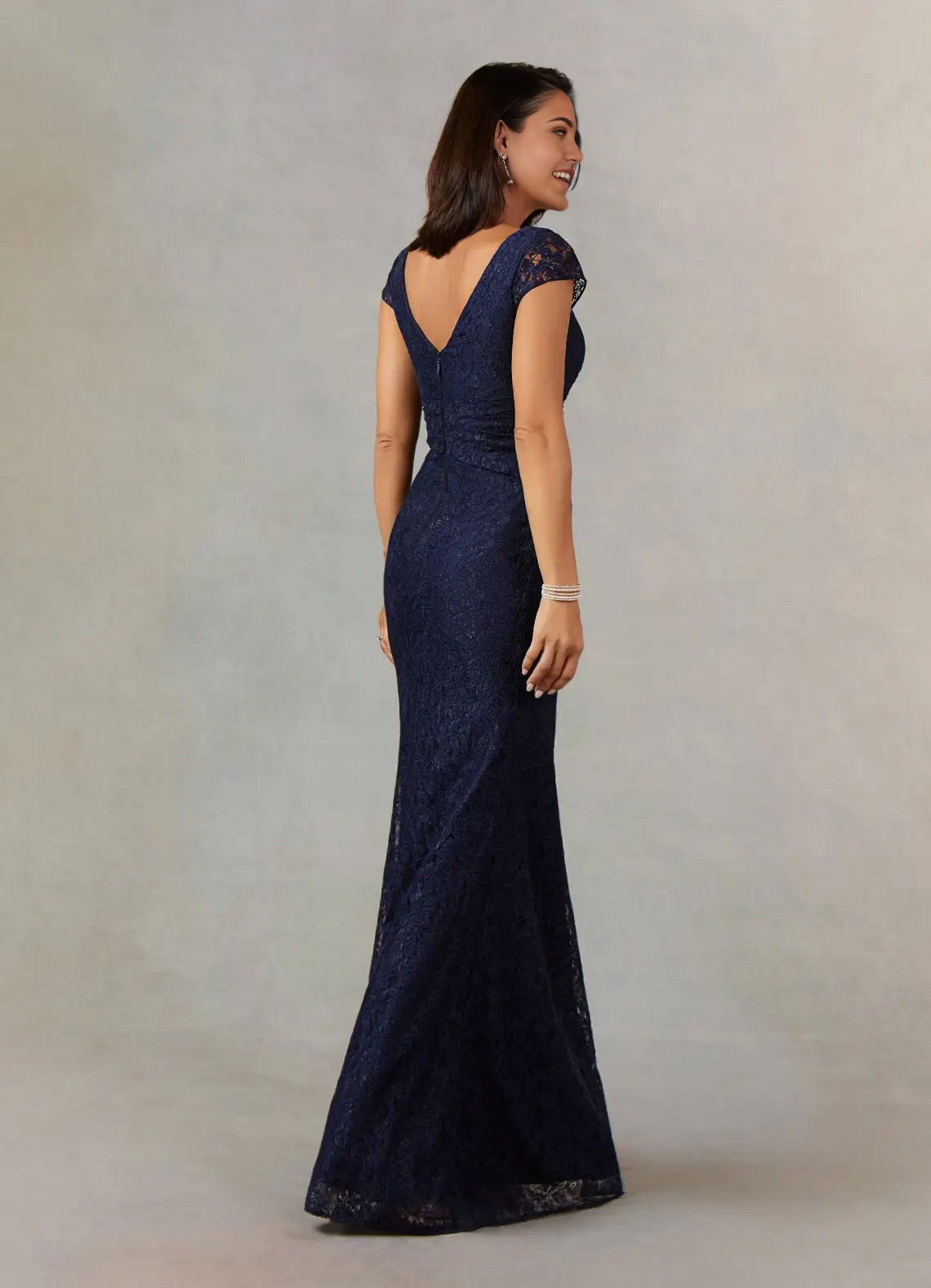 Side view of a dark navy mermaid V-neck pleated lace formal dress.