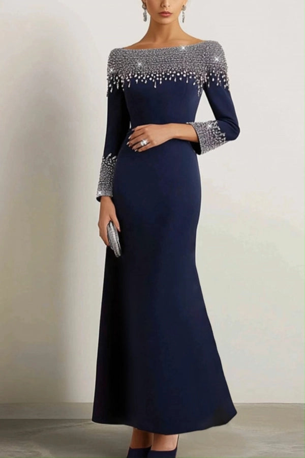 Model wearing a navy A-line boat neck prom dress with rhinestone embellishments.