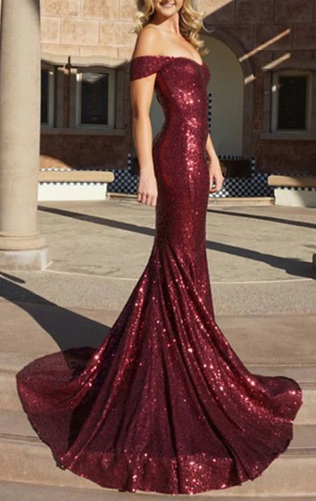 Woman wearing a sparkling navy off-the-shoulder mermaid long prom dress.