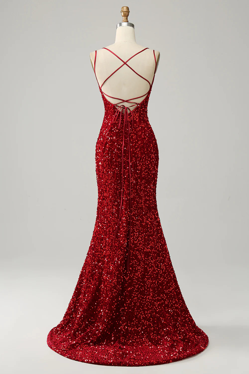 Back view of a red sequined formal gown with a sweep train and backless design.