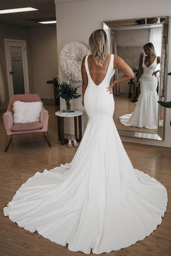 Elegant mermaid wedding dress with a flowing long train, perfect for a beach bridal look.