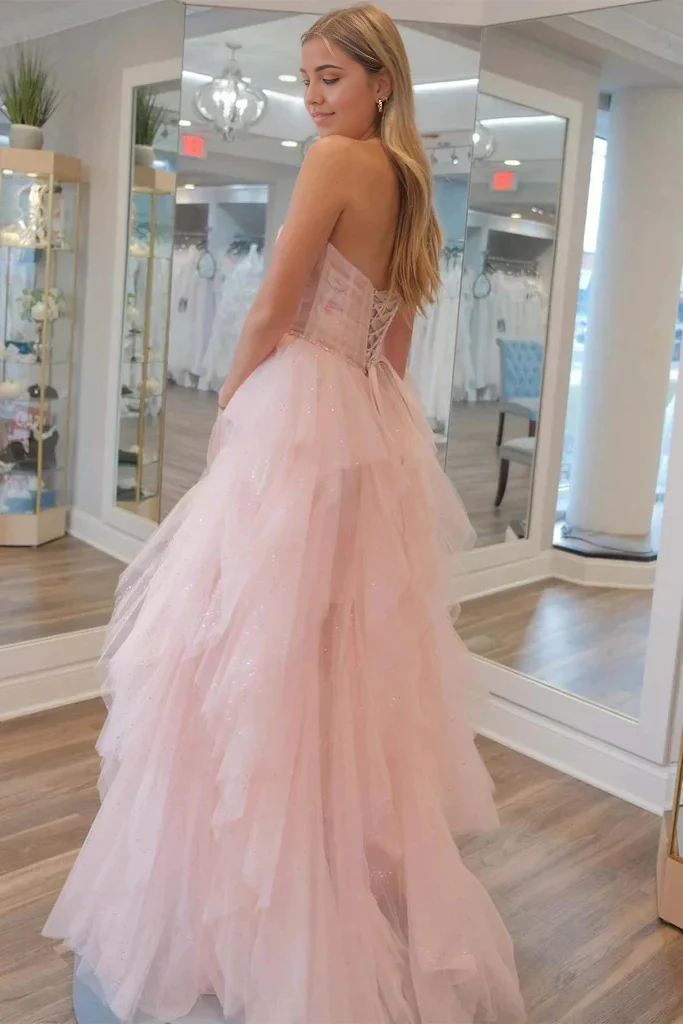 Side view of a woman in a shimmering strapless sequin prom dress.