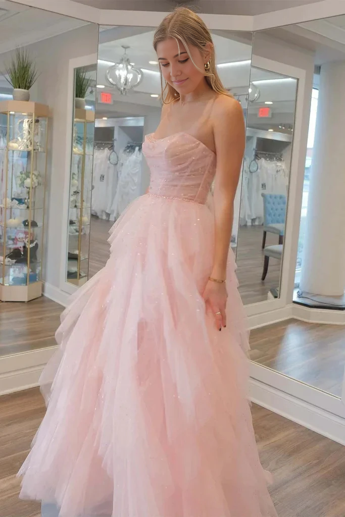 Woman posing in a strapless A-line prom dress, highlighting the flowing tulle skirt.