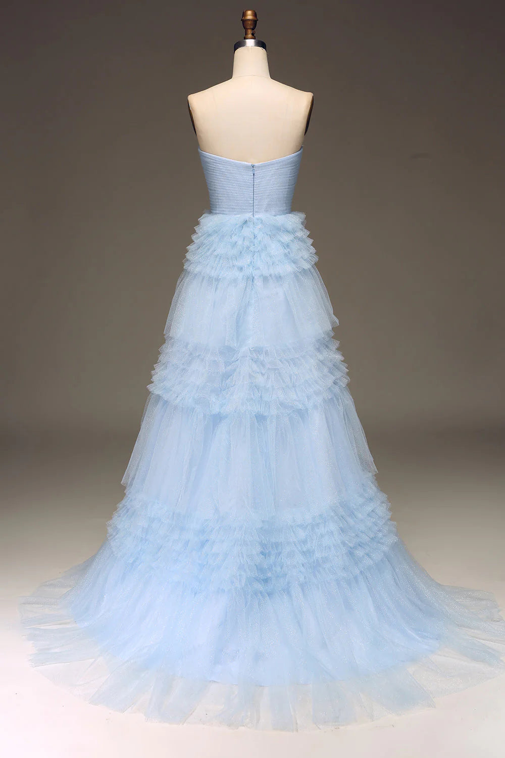 Back view of light blue tulle tiered prom dress with spaghetti straps.