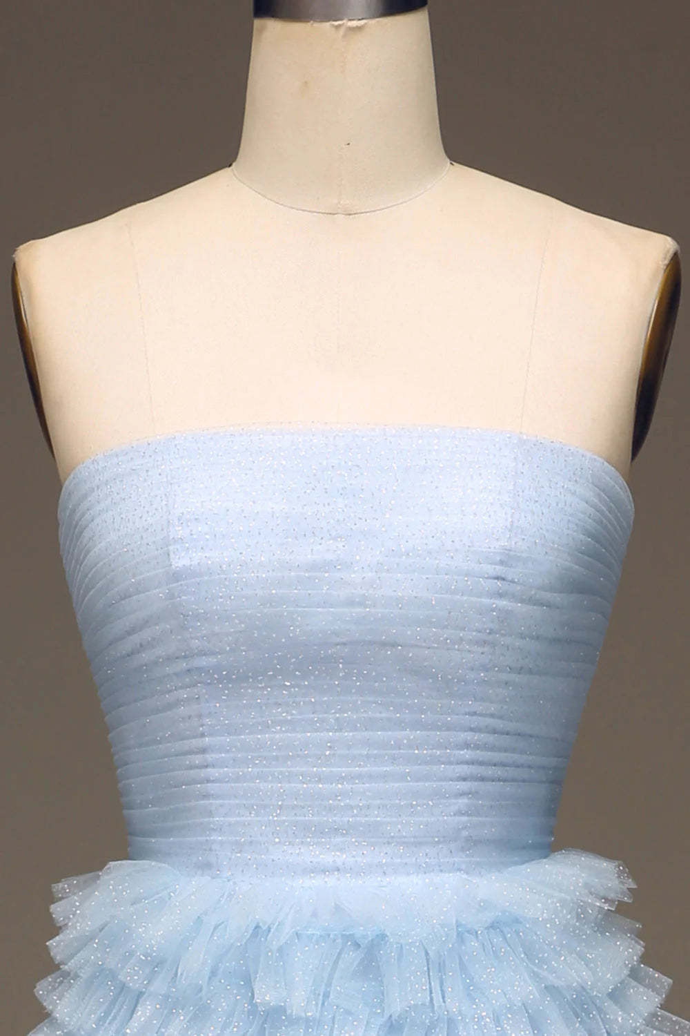 Close-up of light blue tulle fabric and tiered detail on prom dress.