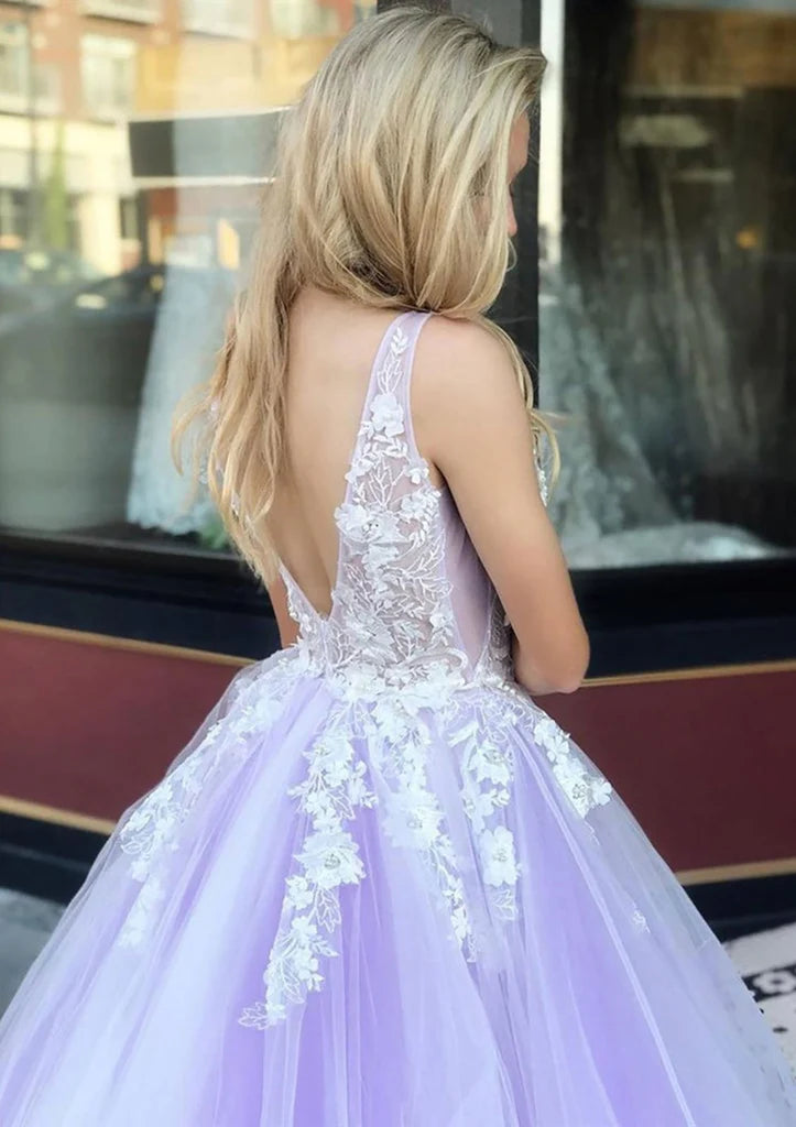 Close-up of the backless detail and flowing tulle skirt of the V-neck ball gown.
