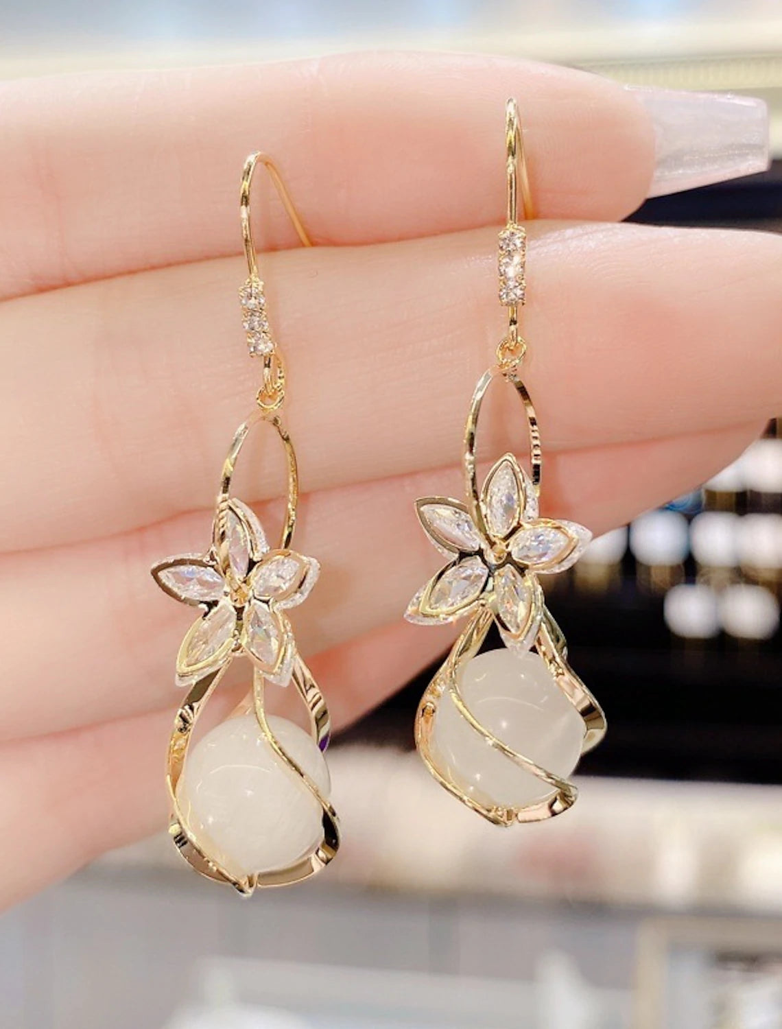 Woman wearing stylish petal opal drop earrings.