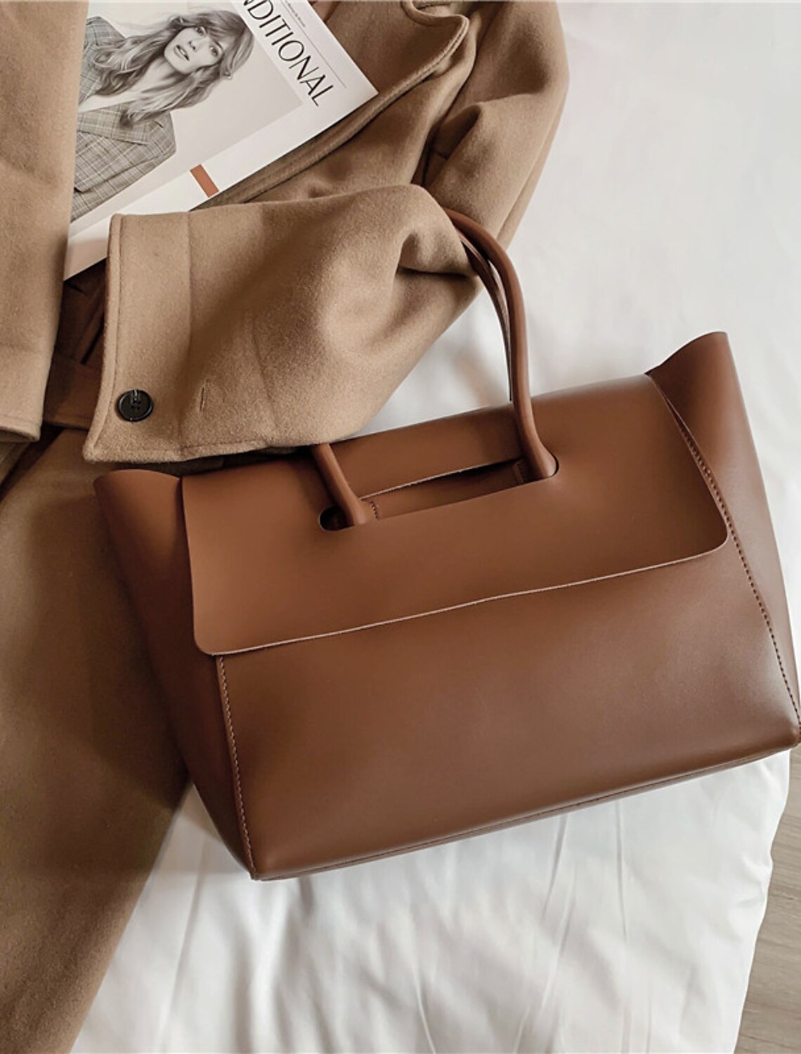 Woman carrying a coffee brown large capacity hobo bag.