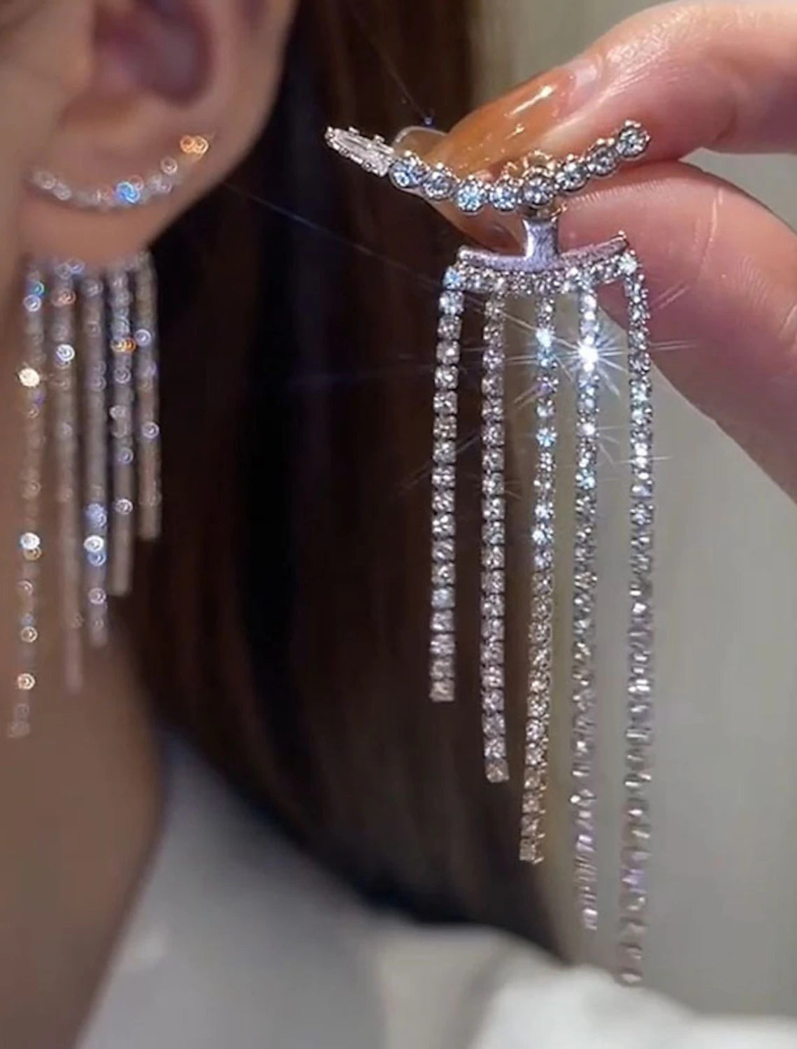 Silver tassel fringe drop earring on a white background.