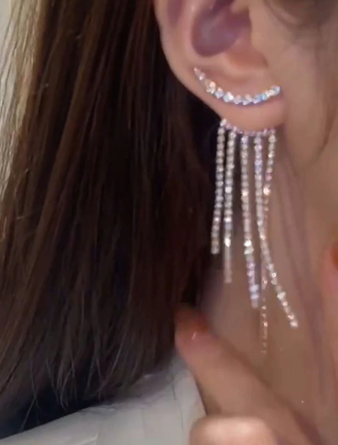 Model wearing silver tassel fringe drop earrings, showcasing their length and movement.