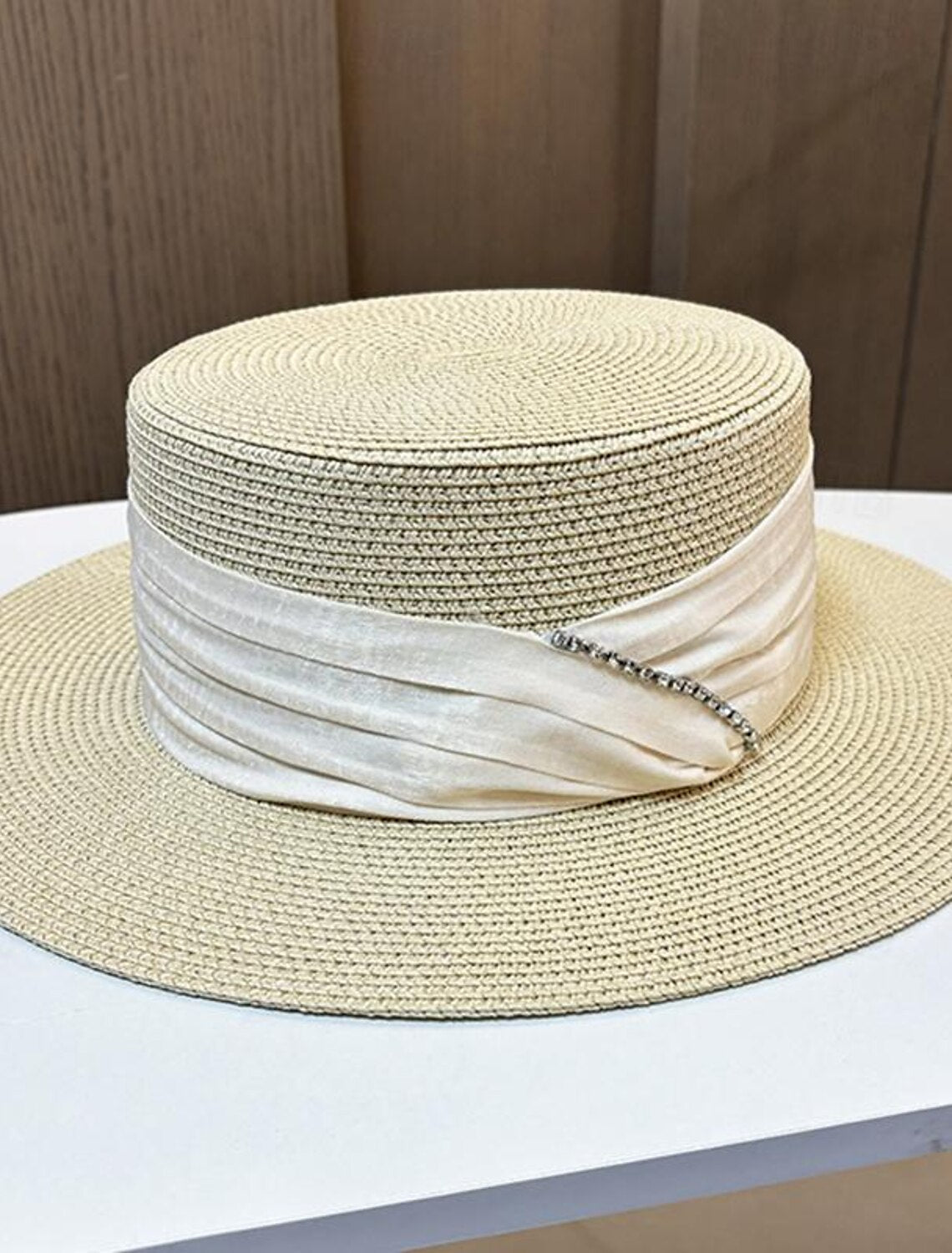 Close-up of the straw fascinator hat with crystal and bow details.