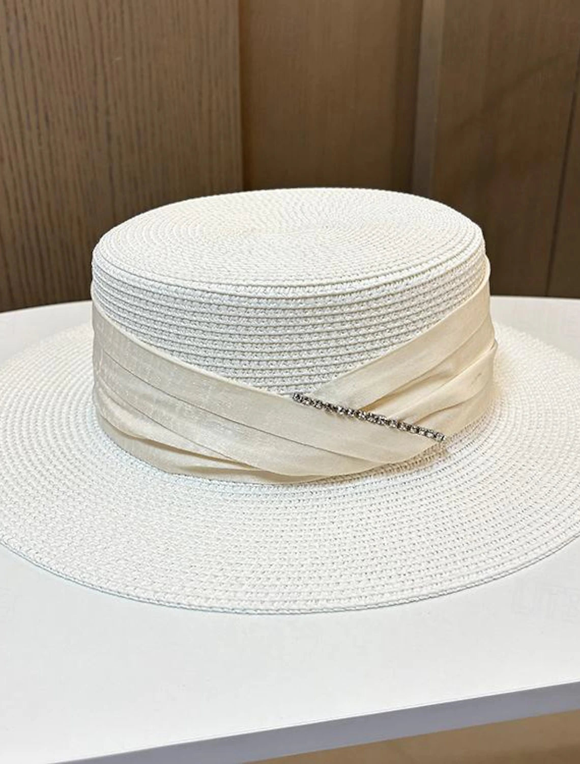 Stylish fascinator hat with bows and crystals, side view.