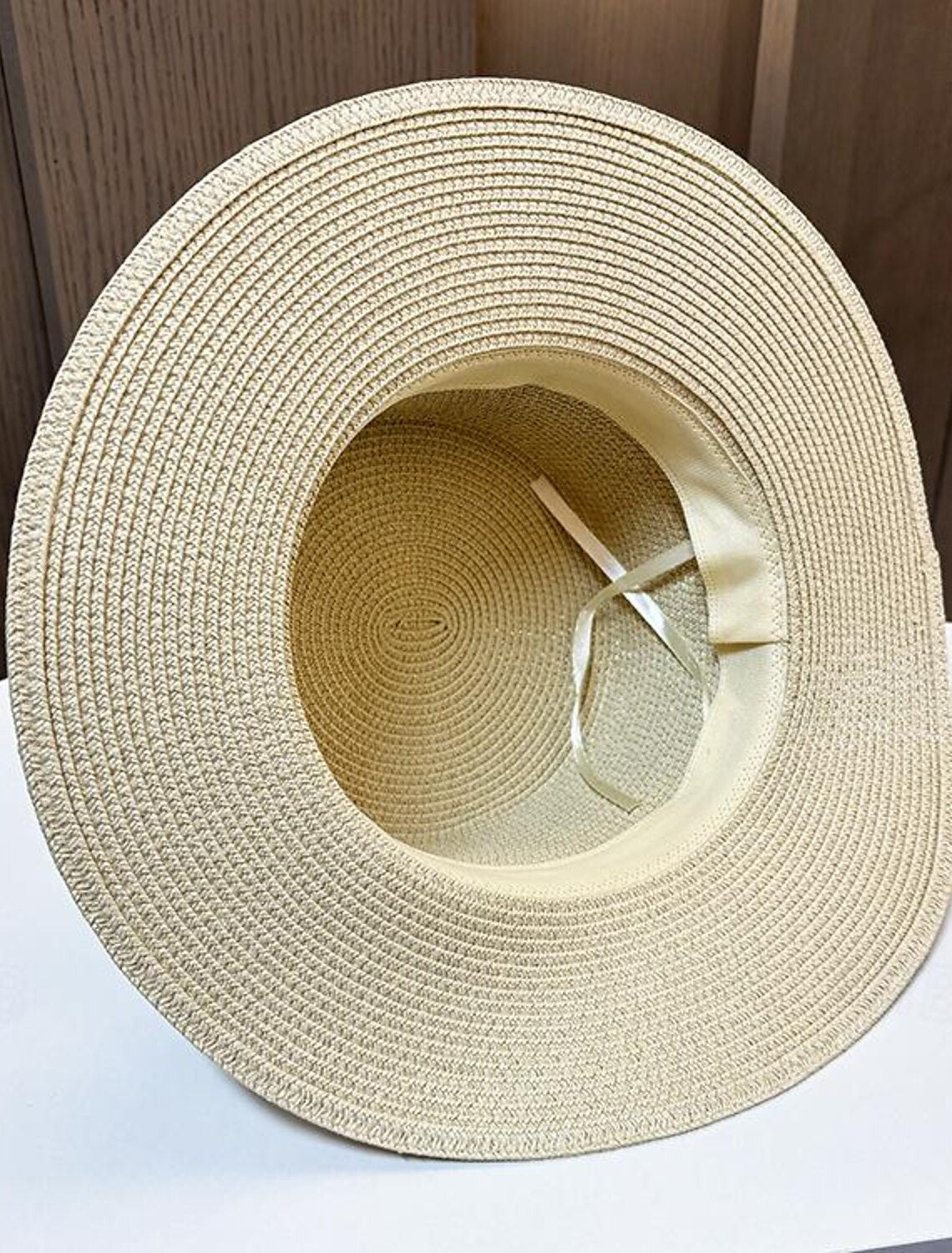 Textured straw fascinator hat with crystal embellishments.
