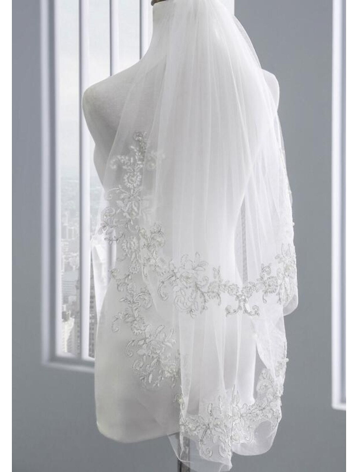 Close-up of the delicate faux pearls on a two-tier elbow wedding veil.