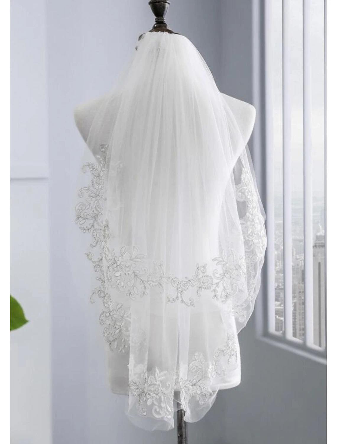 Side view of a bride showcasing a two-tier elbow wedding veil with faux pearls.