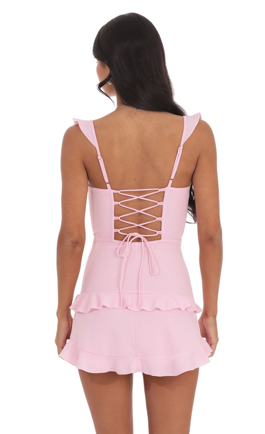 Back view of pink tiered homecoming dress showing lace-up detail.