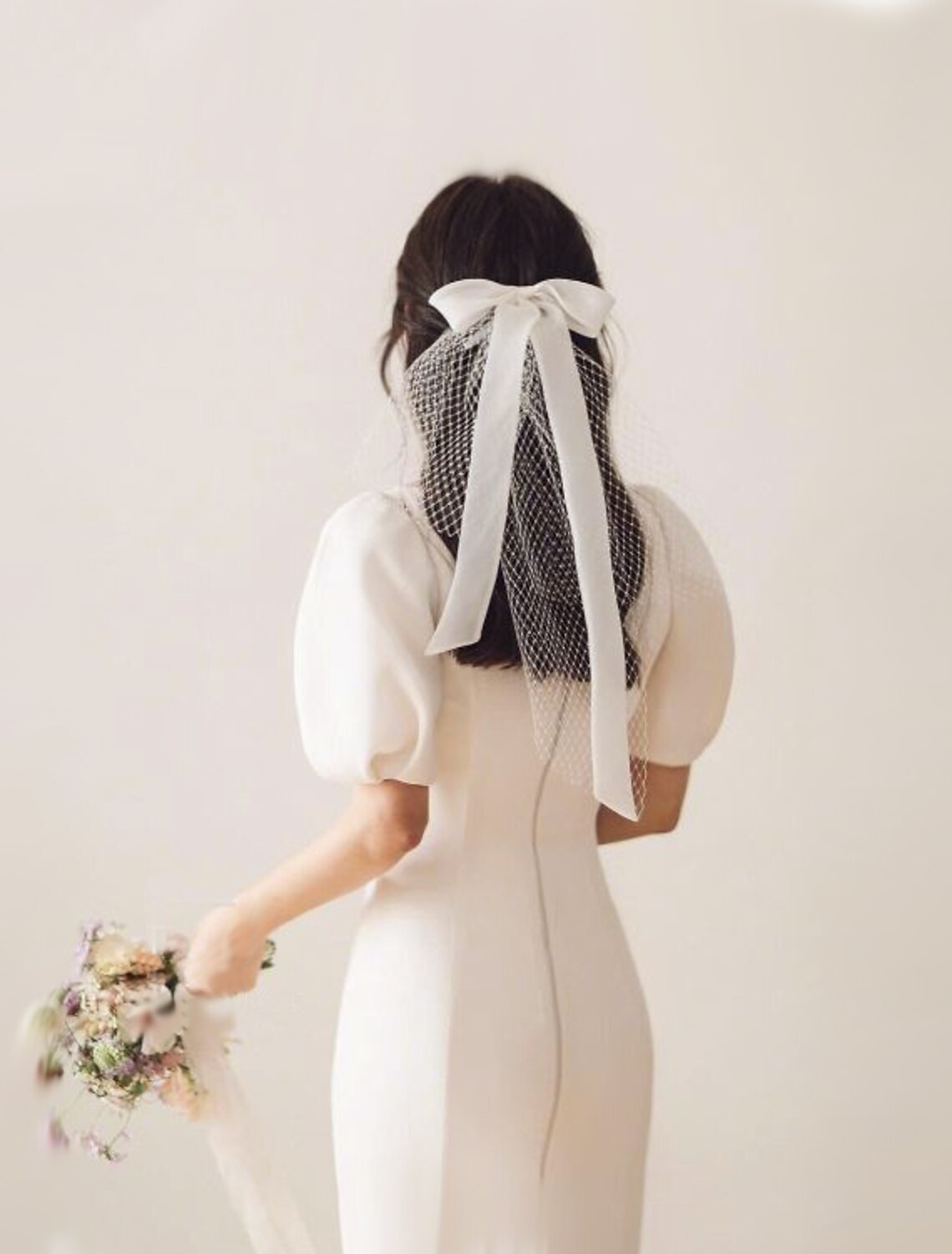 One-tier shoulder wedding veil with a satin bow, made of delicate white tulle.