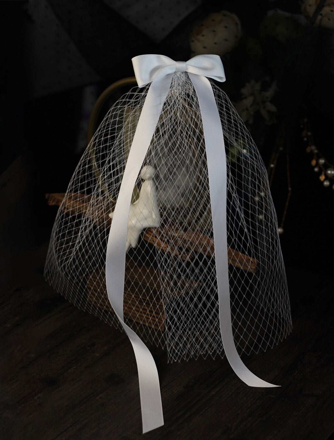 Close-up of a one-tier shoulder wedding veil, showing the satin bow detail and soft tulle fabric.