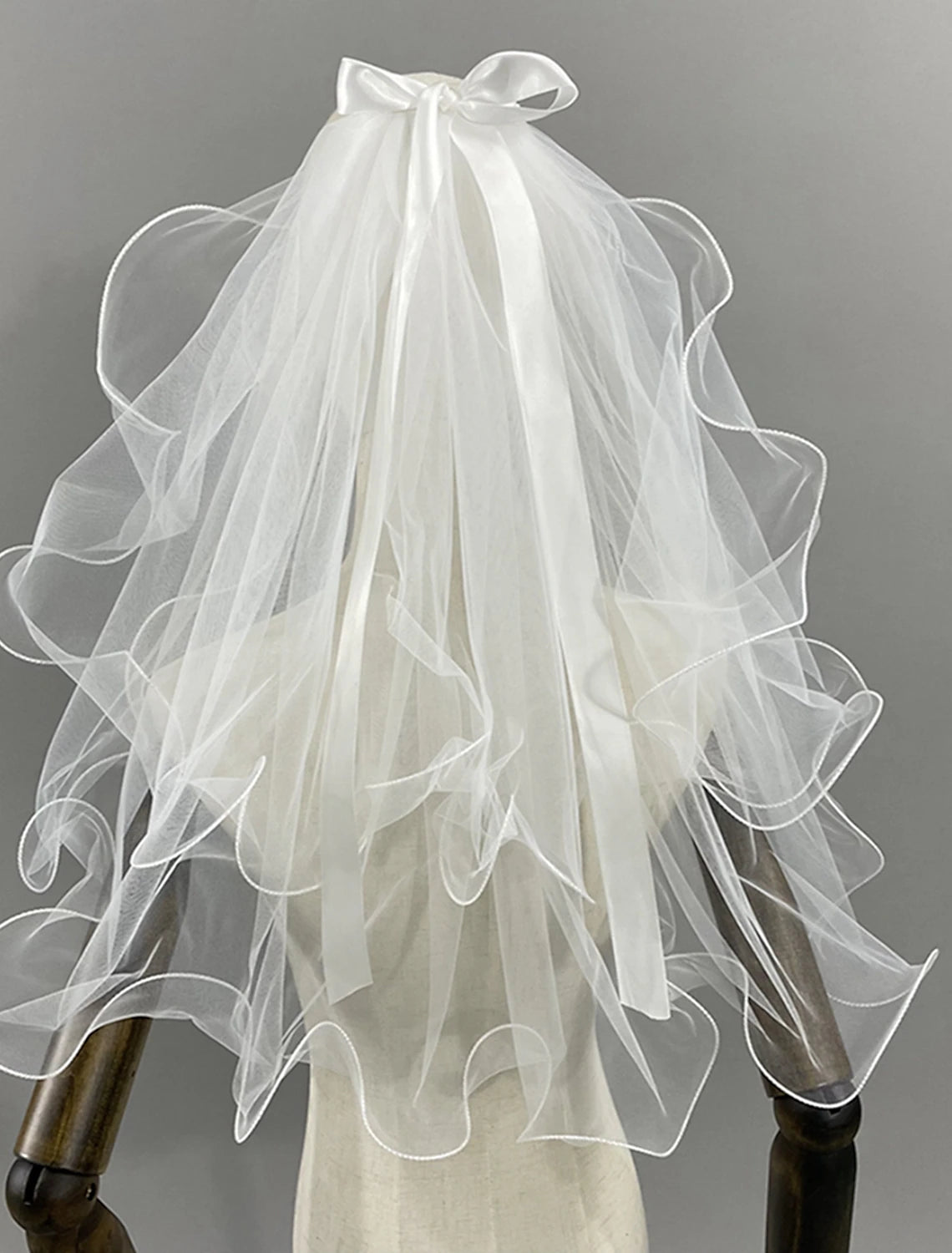 Front view of a bride showcasing the two-tier wedding veil with a sweet design.
