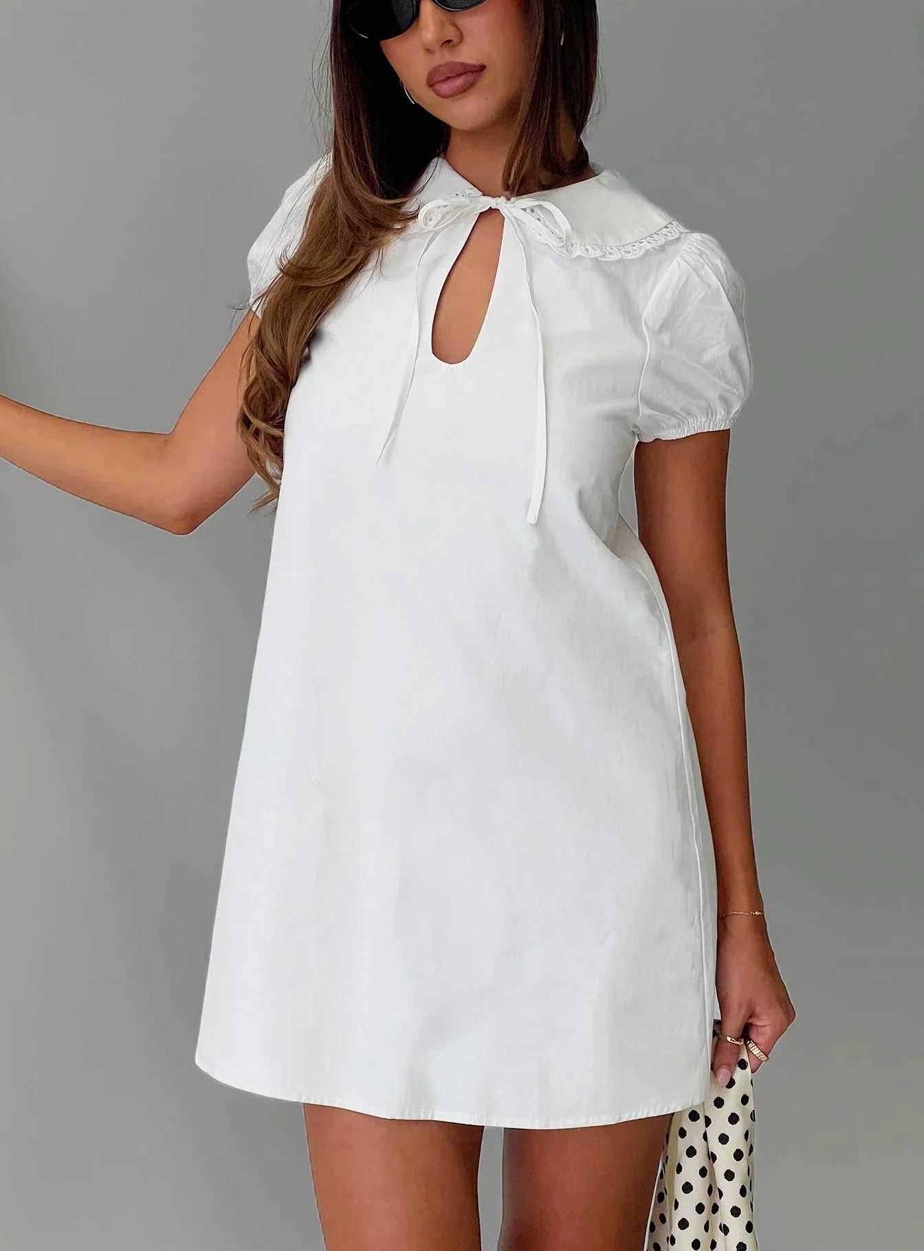 Front view of a white Peter Pan collar mini homecoming dress with puff sleeves.