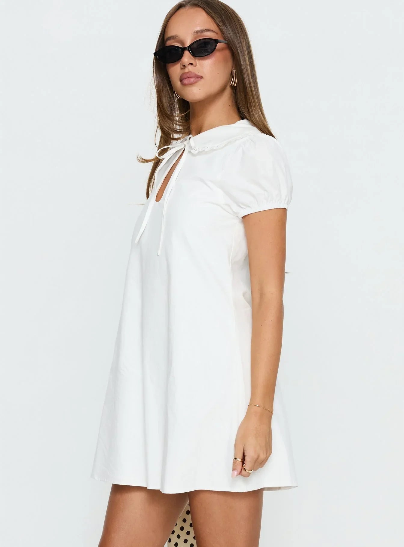 Close-up of the Peter Pan collar and keyhole tie neck on the white dress.