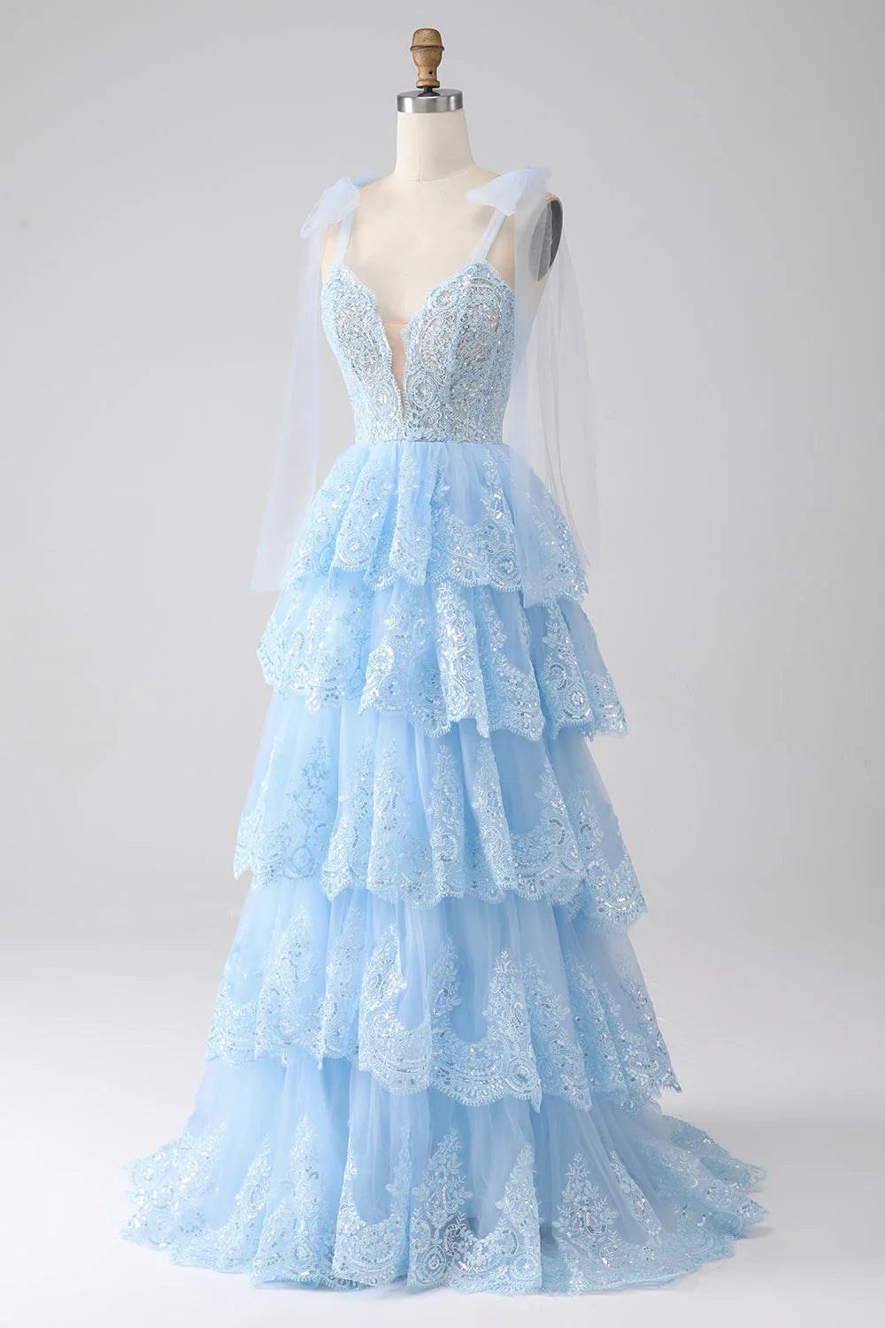 Back view of tiered tulle prom dress with spaghetti straps.