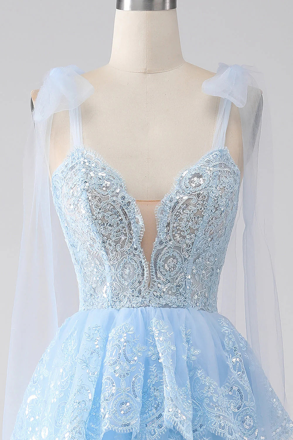 Side view of elegant tiered tulle gown with sequin details.