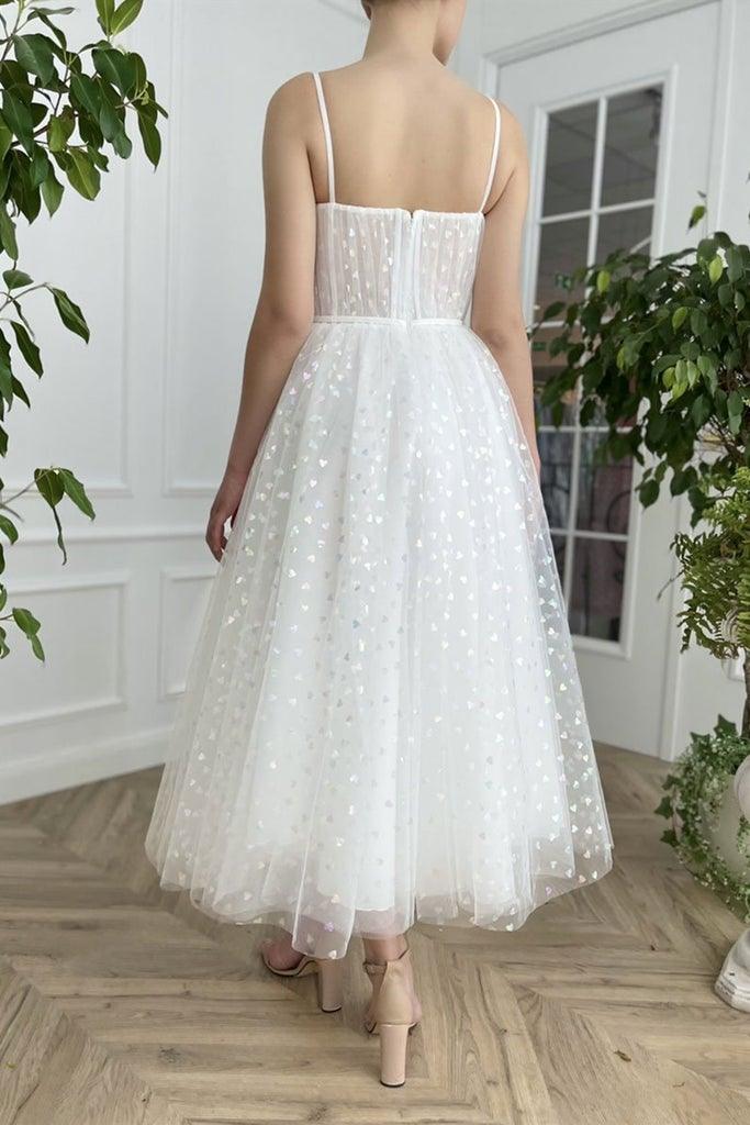 Back view of a woman in a short tulle homecoming dress with sweetheart neckline.