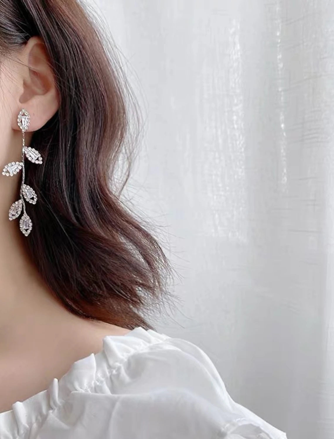 Pair of S925 sterling silver geometrical leaf drop earrings on a white background.