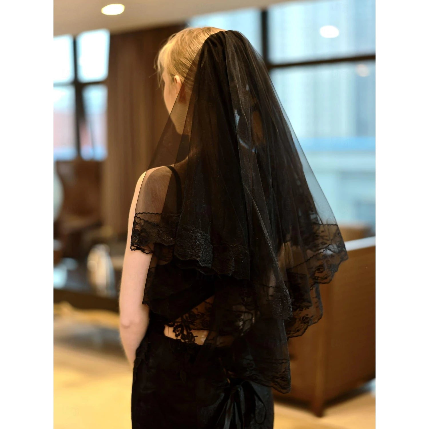 Back view of a bride with an embroidered elbow length veil.