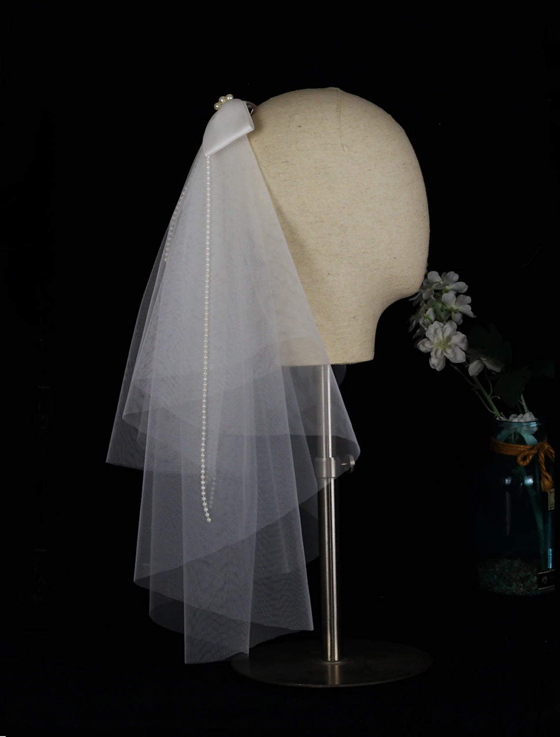 Back view of a bride wearing the two-tier elbow wedding veil, highlighting the satin bow.