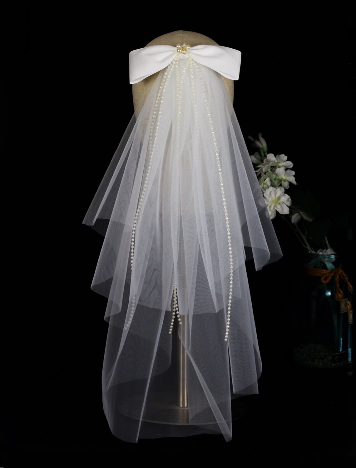 Bride posing with the two-tier elbow wedding veil, showcasing its length and design.