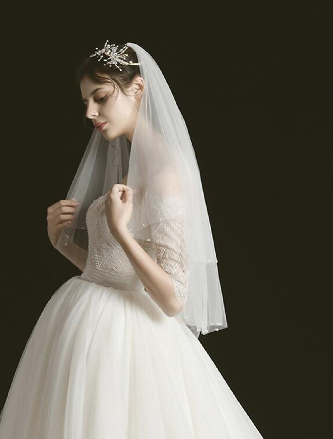 Side view of a bride wearing an 80cm two-tier tulle wedding veil with faux pearls.