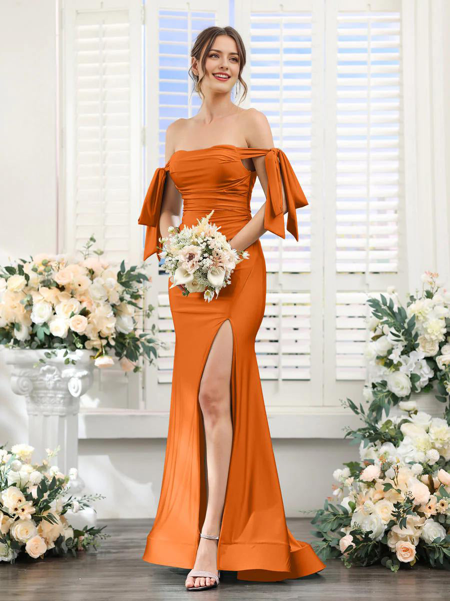 Woman wearing an orange V neck sleeveless split formal dress.