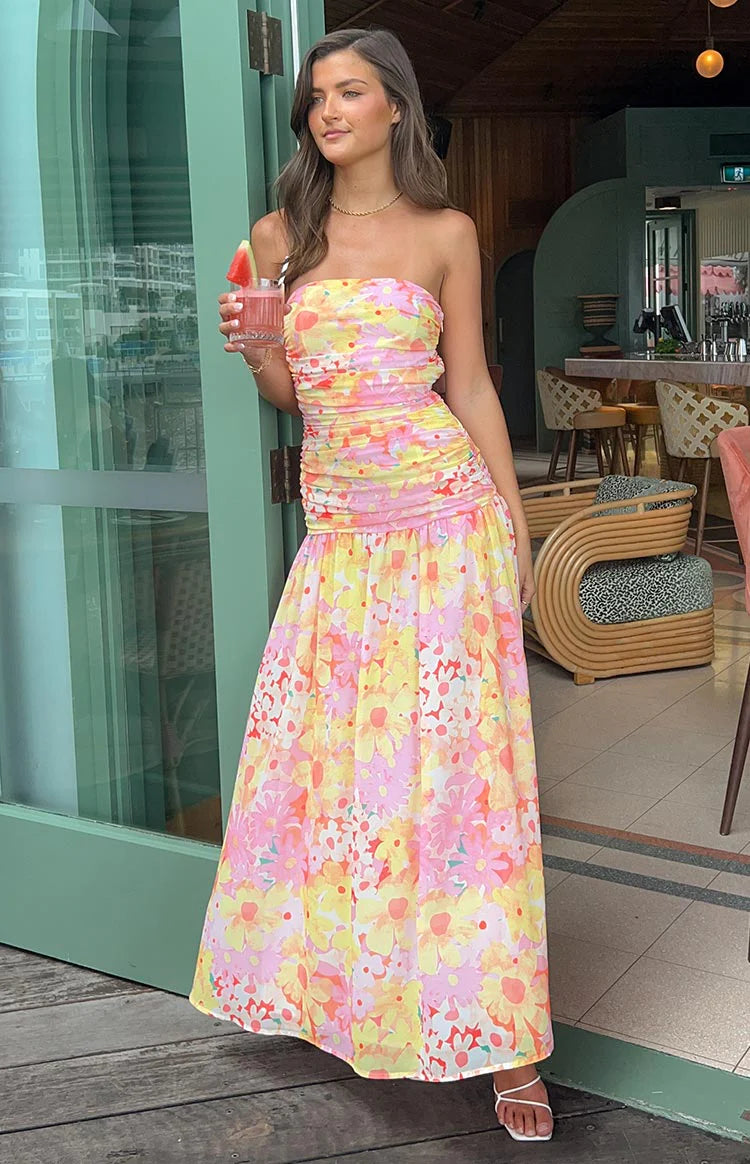 Full length view of a woman in an elegant floral strapless maxi dress.