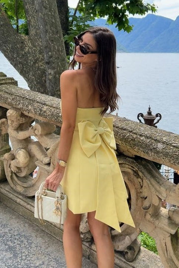 Yellow strapless sheath satin short homecoming dress with a decorative bow.