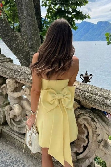 Back view of a yellow strapless satin short homecoming dress.