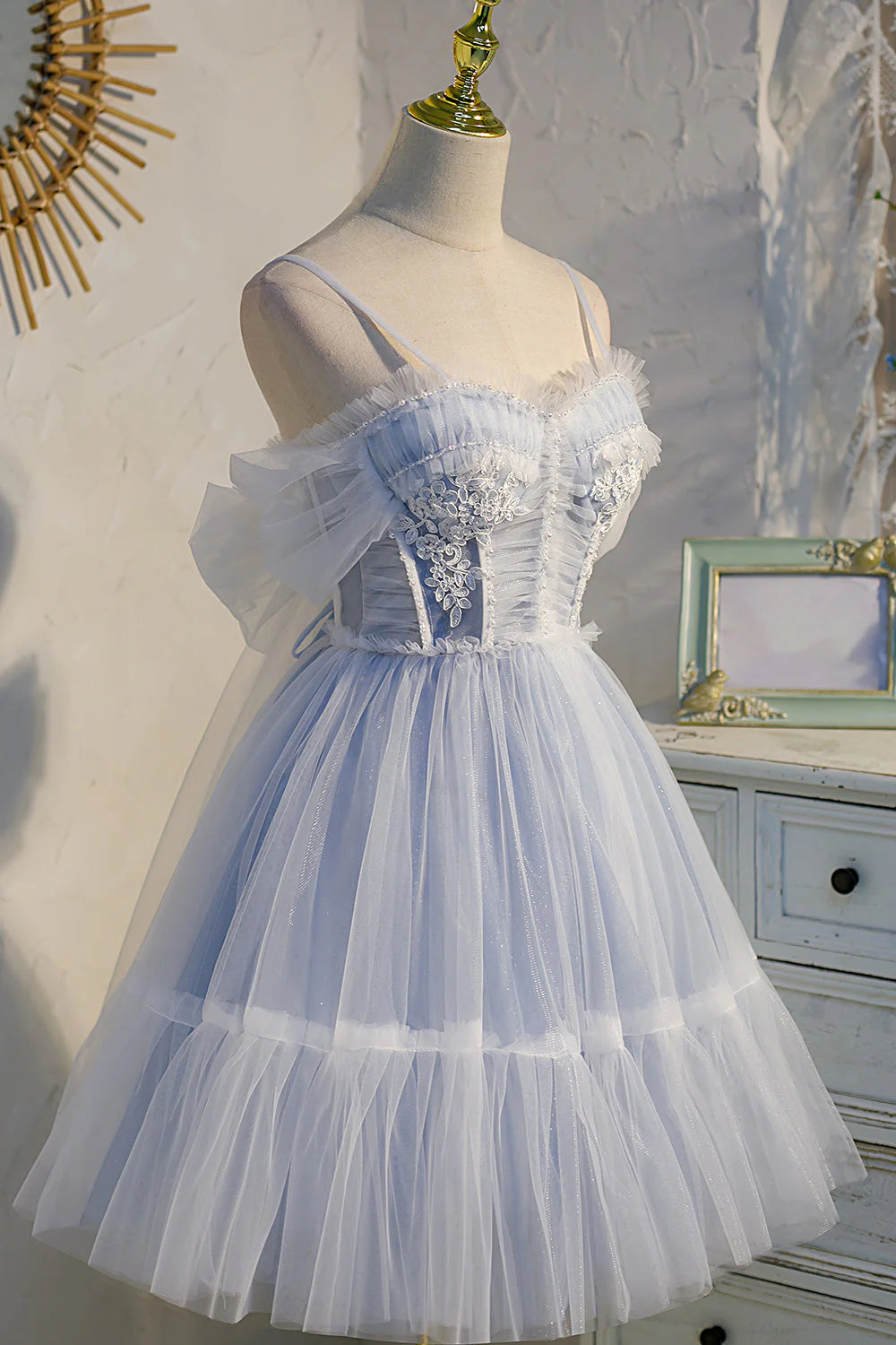 Side view of a model in a short black tulle prom dress, highlighting the sweetheart neckline.