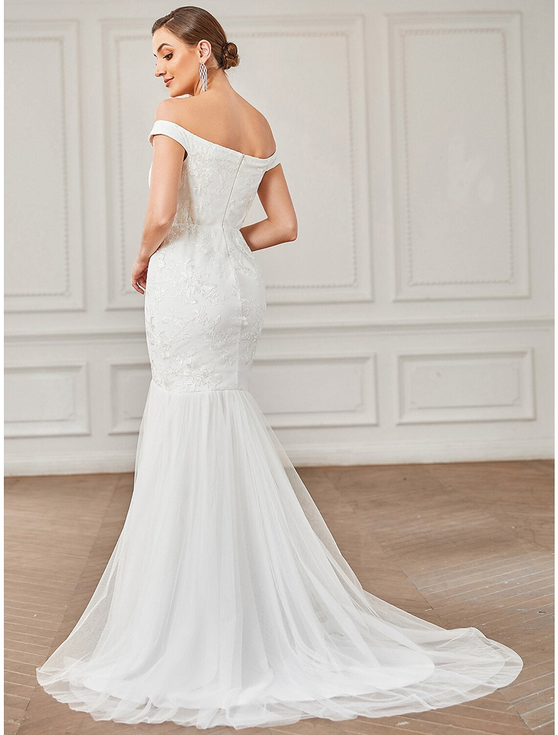 Detail of the off-shoulder neckline and cap sleeves on the lace wedding dress.