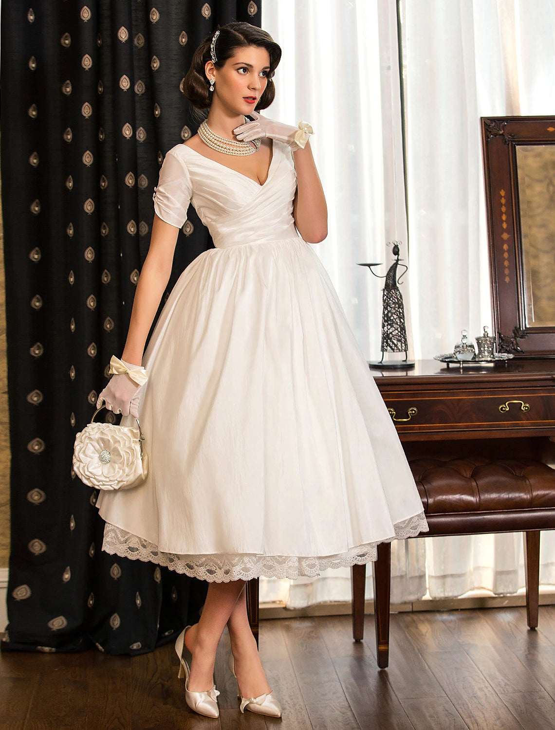 Back view of vintage A-line V-neck short sleeve white tea length wedding dress with lace criss-cross.