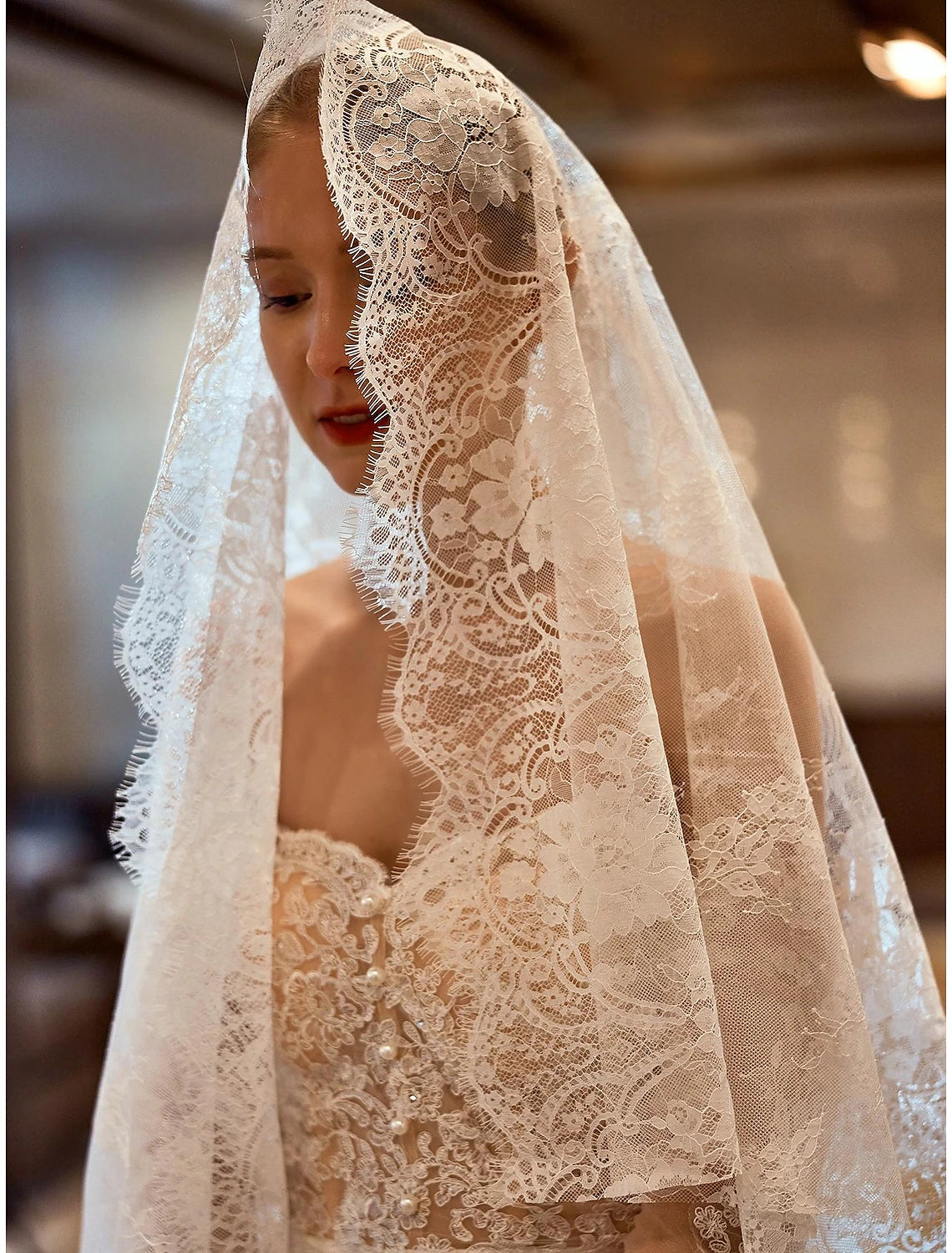 Side profile of a bride with the vintage embroidered lace wedding veil.