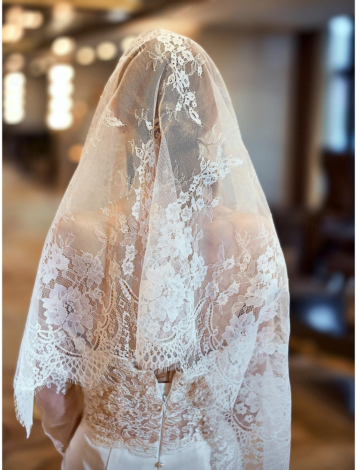 Detailed view of the one-tier wedding veil's fabric and lace pattern.