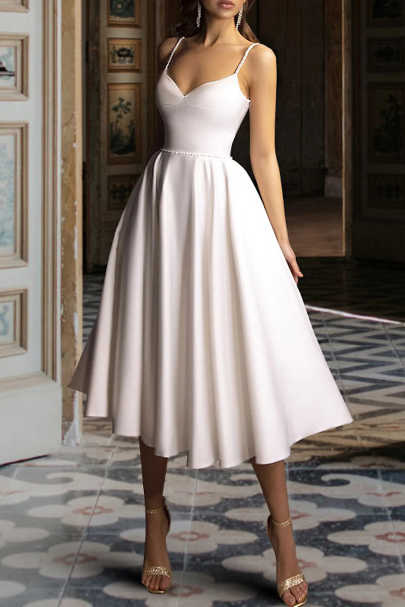 Front view of a model wearing a vintage tea-length wedding dress with delicate details.