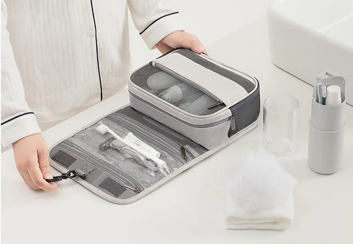 Open water-resistant toiletry bag with multiple compartments and a hanging hook.